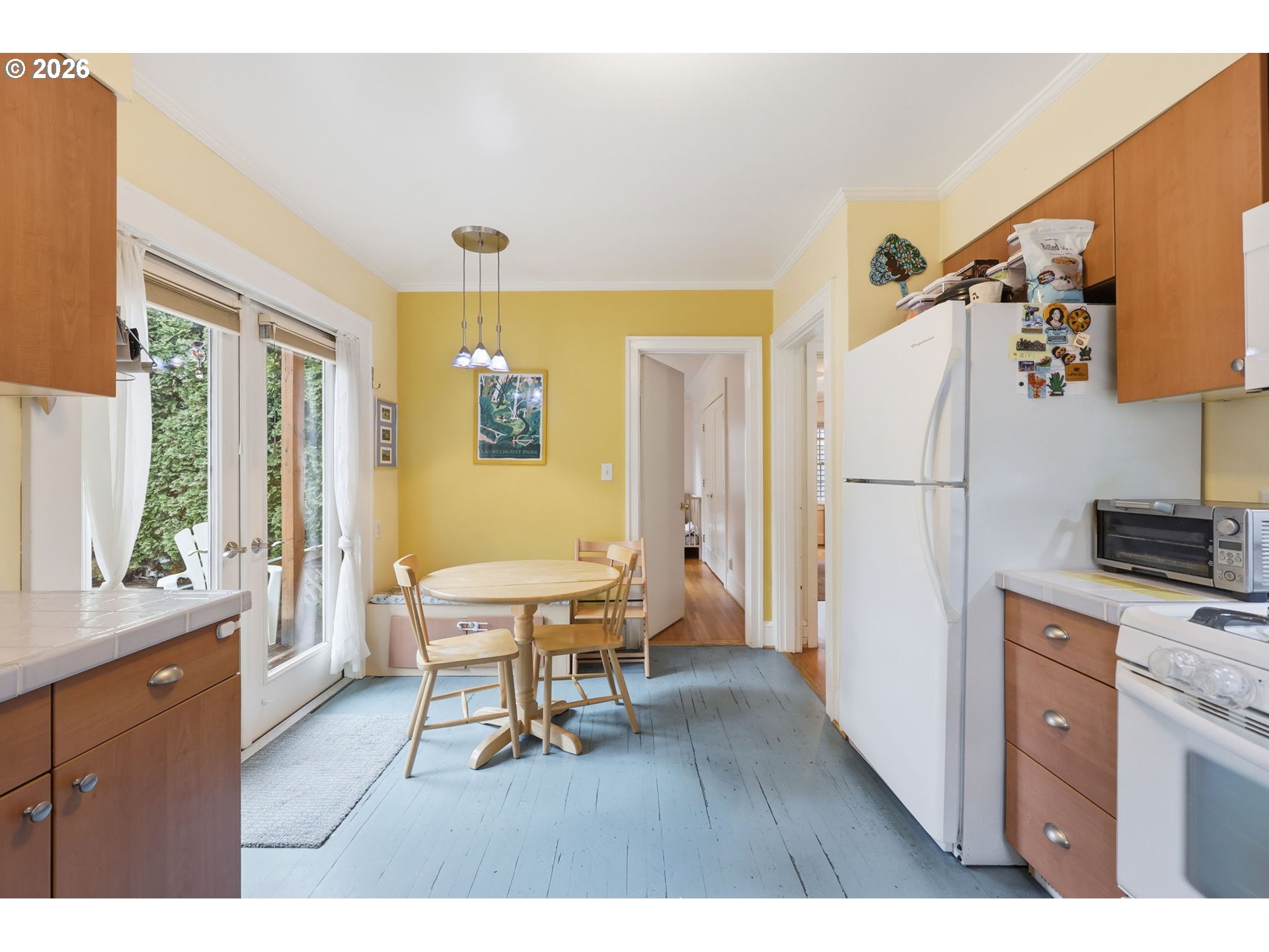 3136 Northeast Couch Street Portland, OR 97232 - Photo 15 of 48 a living room with a dining table wooden floor and a refrigerator