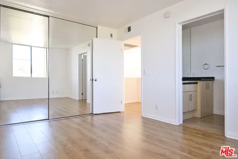 a view of empty room with wooden floor and cabinet