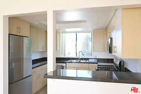 a kitchen with granite countertop a refrigerator and a stove