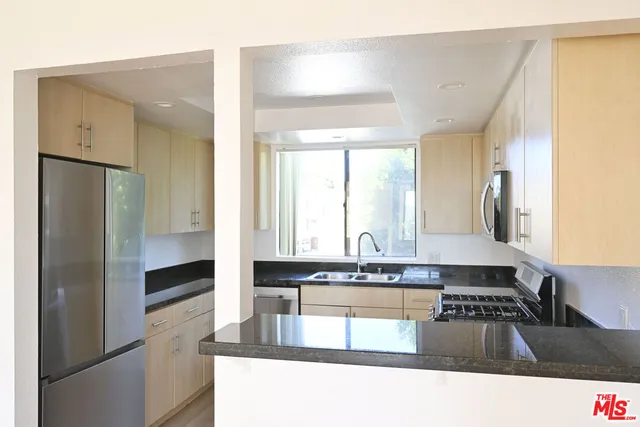 a kitchen with granite countertop a refrigerator and a stove