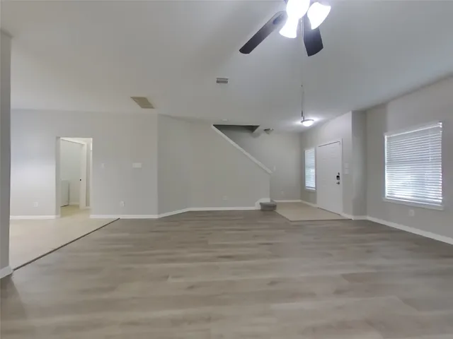 an empty room with fan and windows