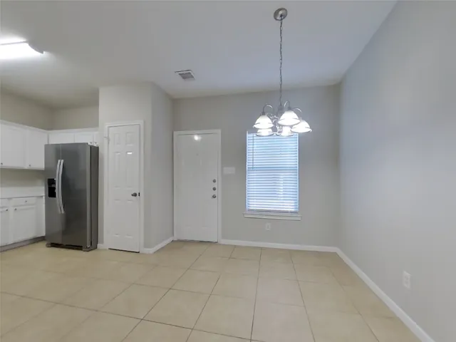 a view of a chandelier fan and refrigerator in a kitchen