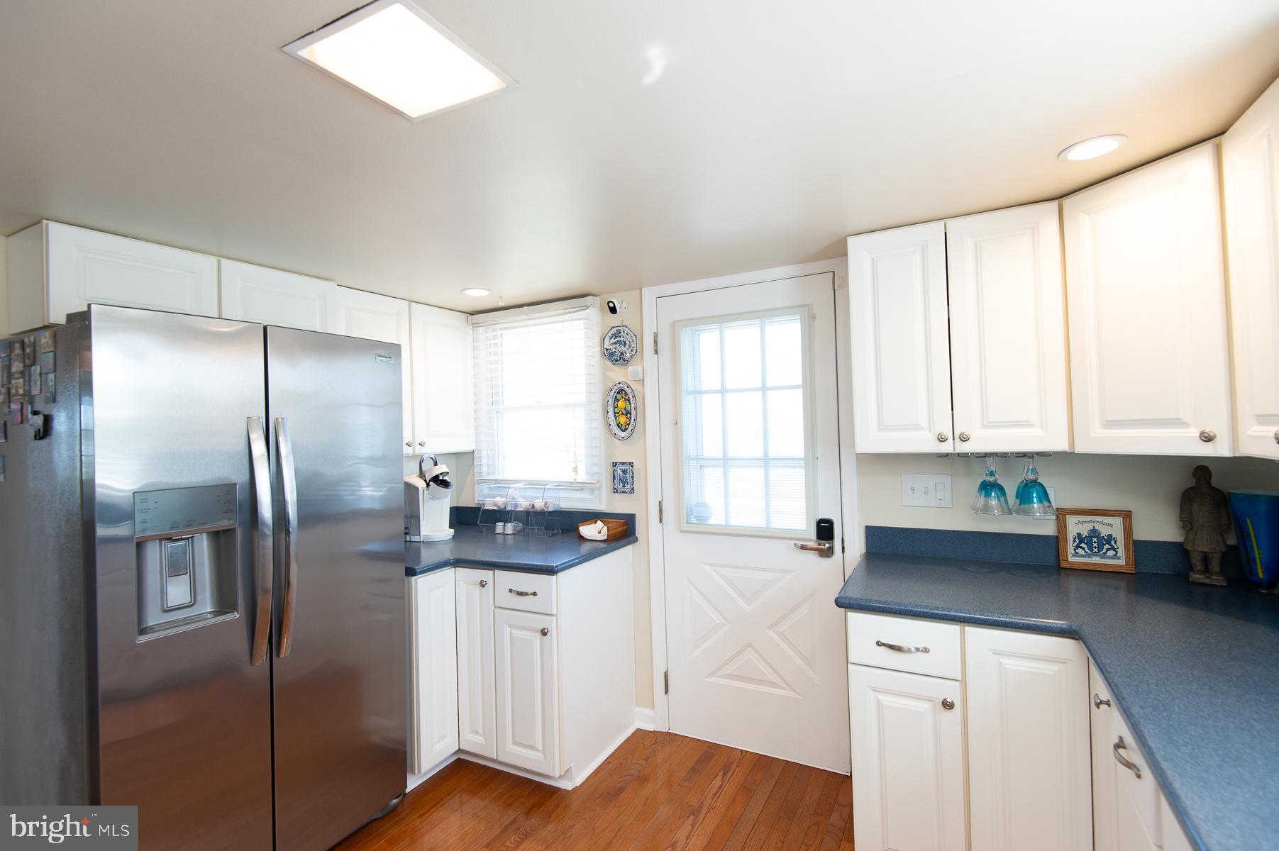 5558 Bowen Road Cambridge, MD 21613 - Photo 6 of 33 a kitchen with stainless steel appliances granite countertop a refrigerator a sink a stove and white cabinets with wooden floor