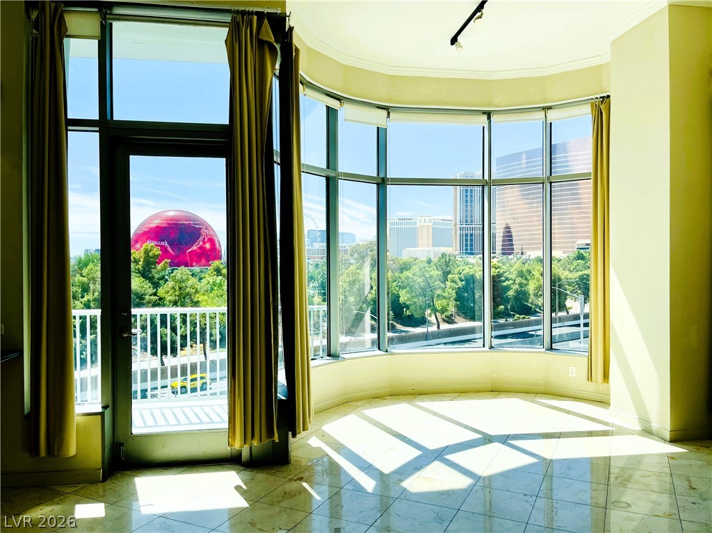 360 East Desert Inn Road, Unit 507 Las Vegas, NV 89109 - Photo 5 of 37 Floor-to-ceiling windows frame panoramic city vistas across polished tile flooring.