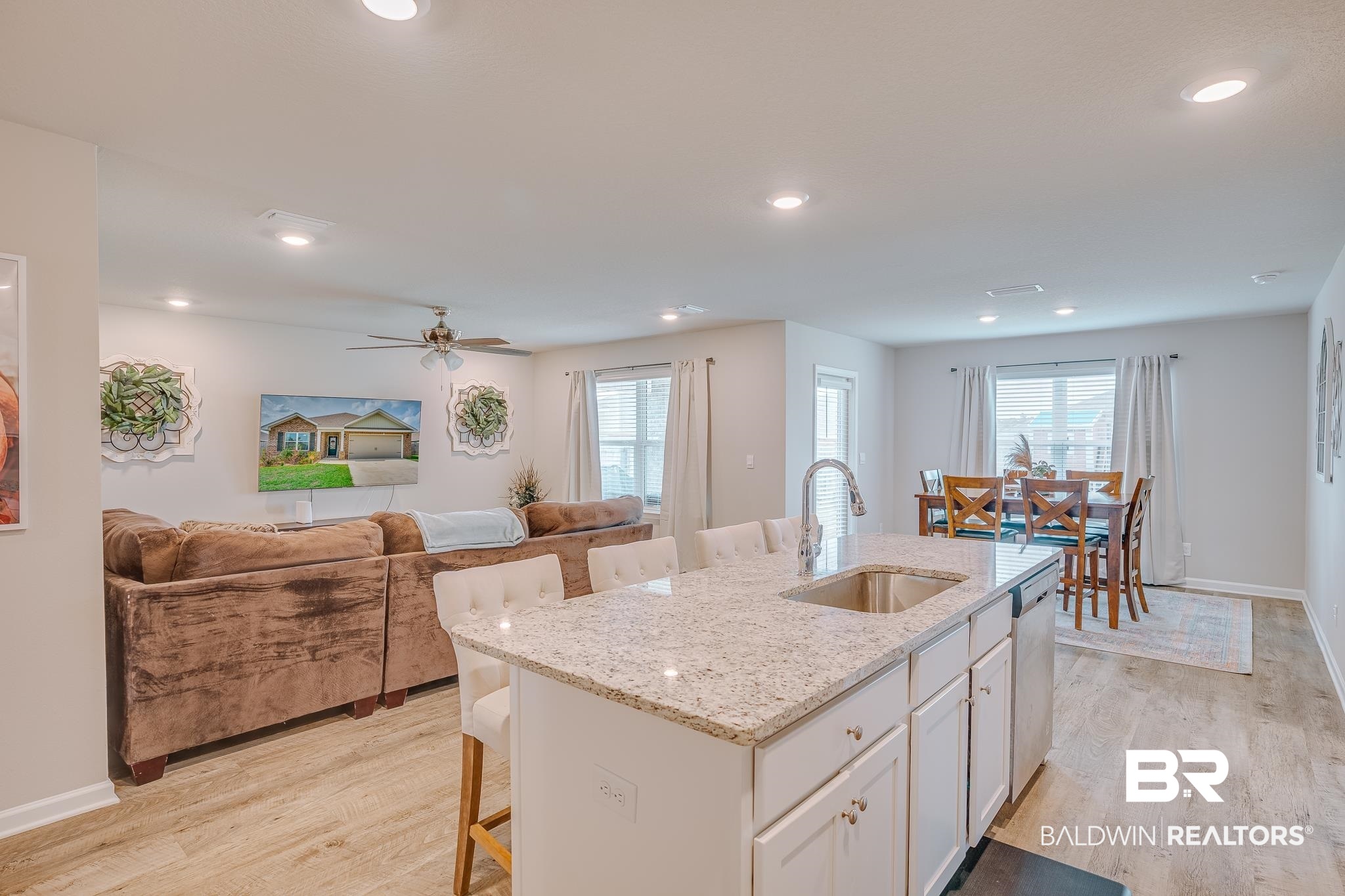 8242 Sycamore Way Semmes, AL 36575 - Photo 42 of 43 Kitchen featuring a kitchen breakfast bar, light wood finished floors, open floor plan, white cabinets, and recessed lighting