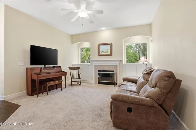 a living room with furniture a flat screen tv and a fireplace