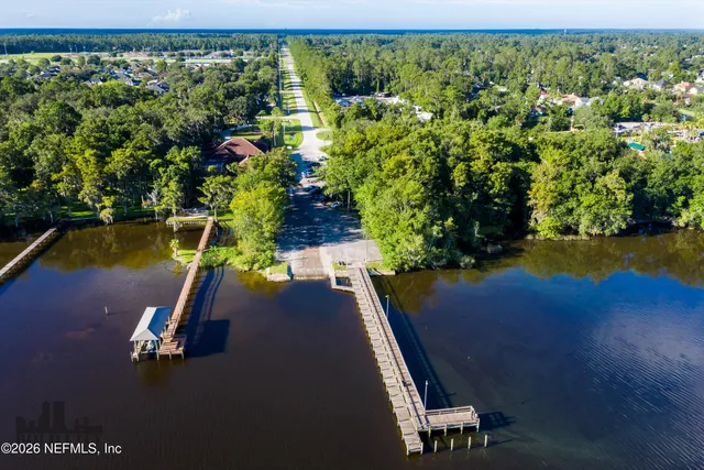 a view of a swimming pool with lawn chairs and plants