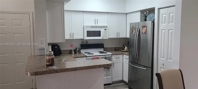 a kitchen with stainless steel appliances granite countertop a refrigerator sink and stove