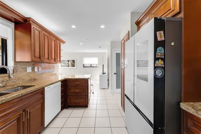 a kitchen with stainless steel appliances granite countertop a refrigerator and a sink
