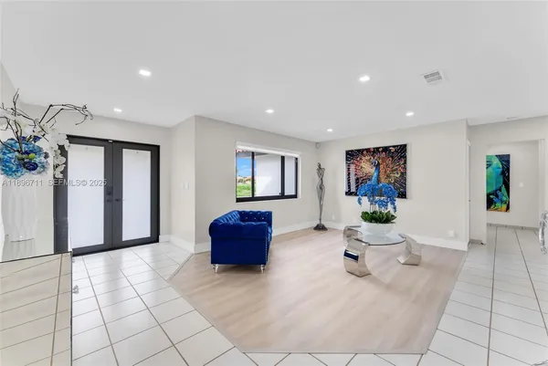 a living room with furniture and a painting on the wall