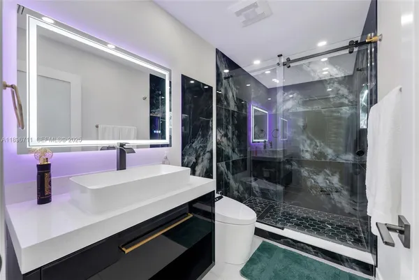 a bathroom with a sink mirror and a shower