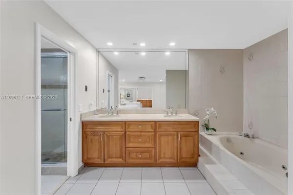 a spacious bathroom with a granite countertop sink mirror and a bathtub