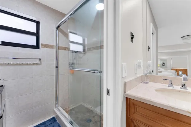 a bathroom with a shower sink and mirror