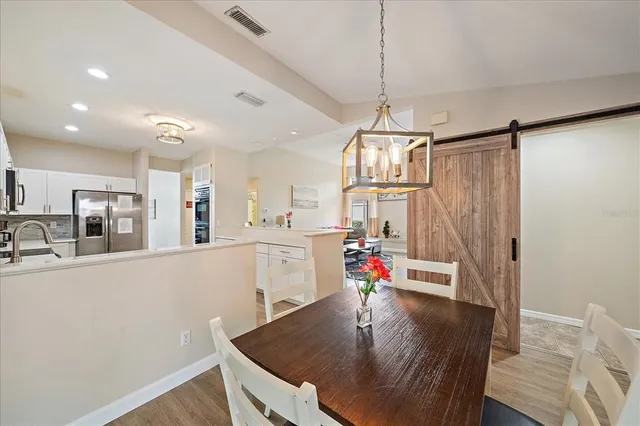 a kitchen with stainless steel appliances granite countertop a sink dishwasher and a refrigerator with wooden floor