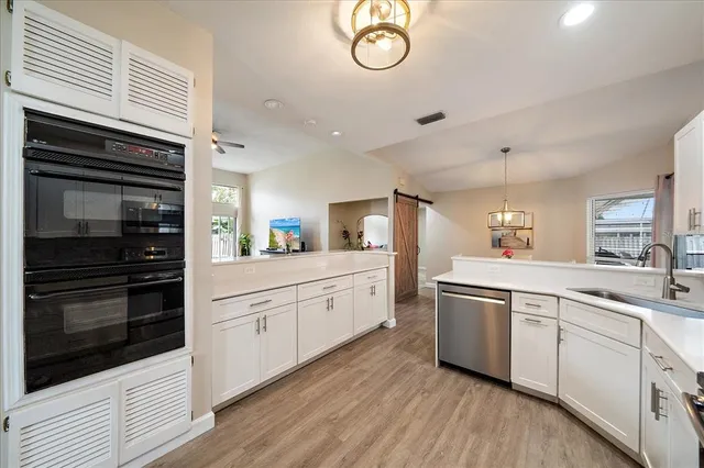 a kitchen with white cabinets and stainless steel appliances