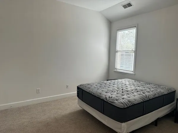 a bed sitting in a bedroom next to a window