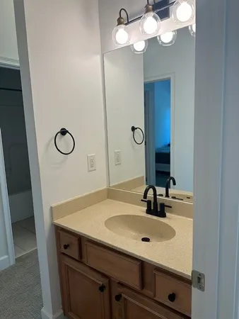 a bathroom with a sink a light fixture and a mirror