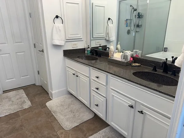 a bathroom with double sink and a mirror
