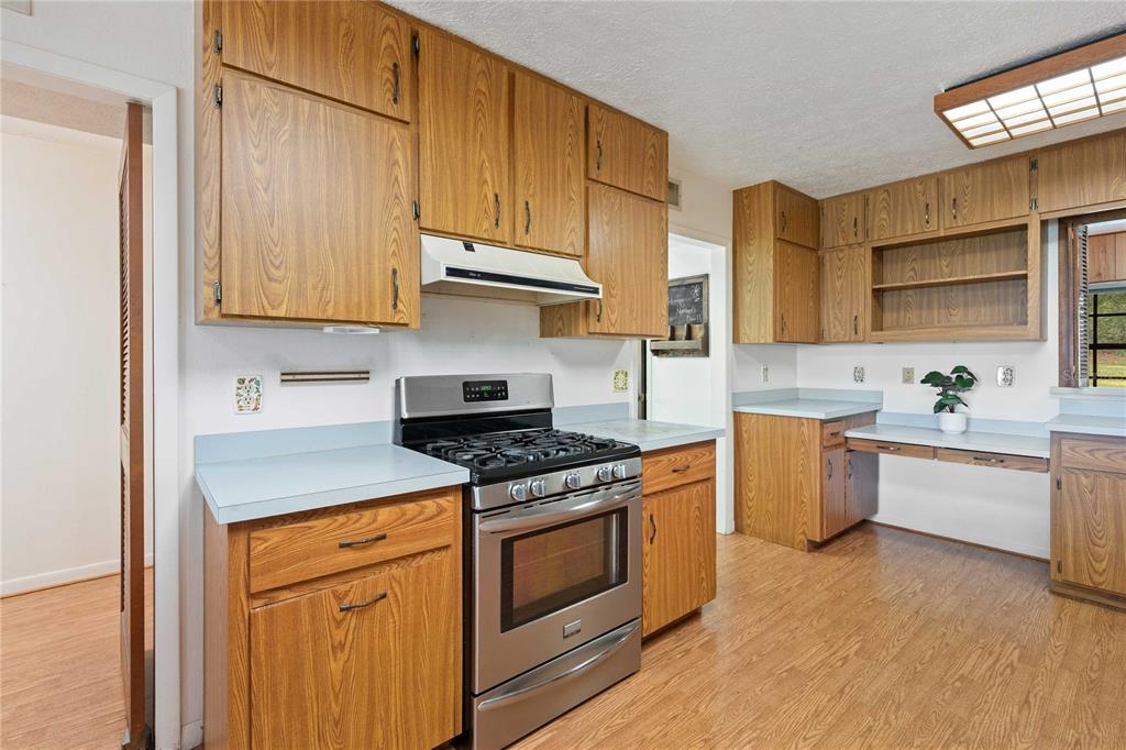 14835 Ramsey Road Dade City, FL 33523 - Photo 19 of 59 a kitchen with stainless steel appliances granite countertop a stove a sink and a refrigerator
