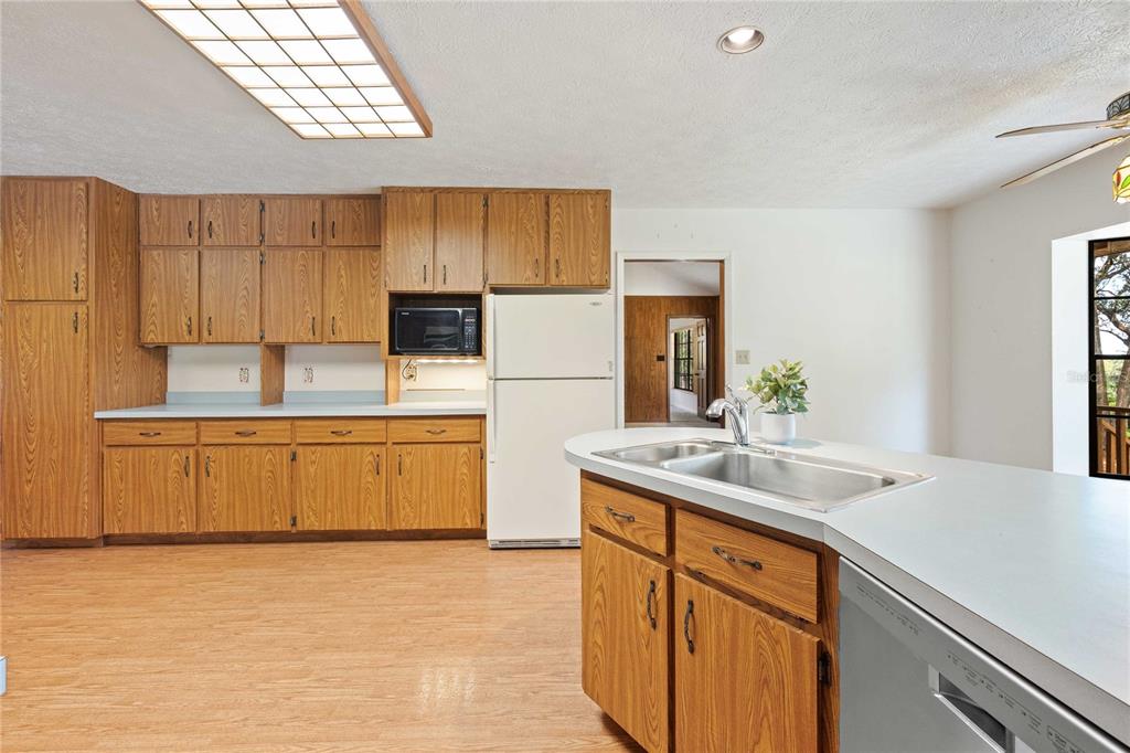 14835 Ramsey Road Dade City, FL 33523 - Photo 21 of 59 a kitchen with a sink a stove a refrigerator and cabinets