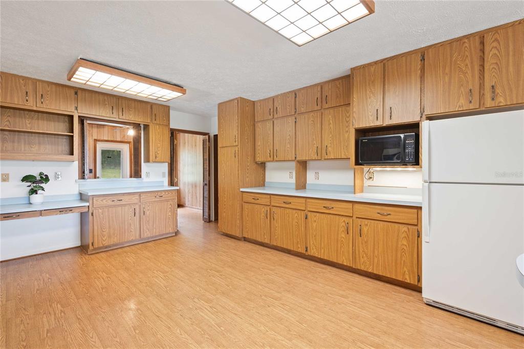 14835 Ramsey Road Dade City, FL 33523 - Photo 22 of 59 a kitchen with stainless steel appliances a refrigerator sink and cabinets