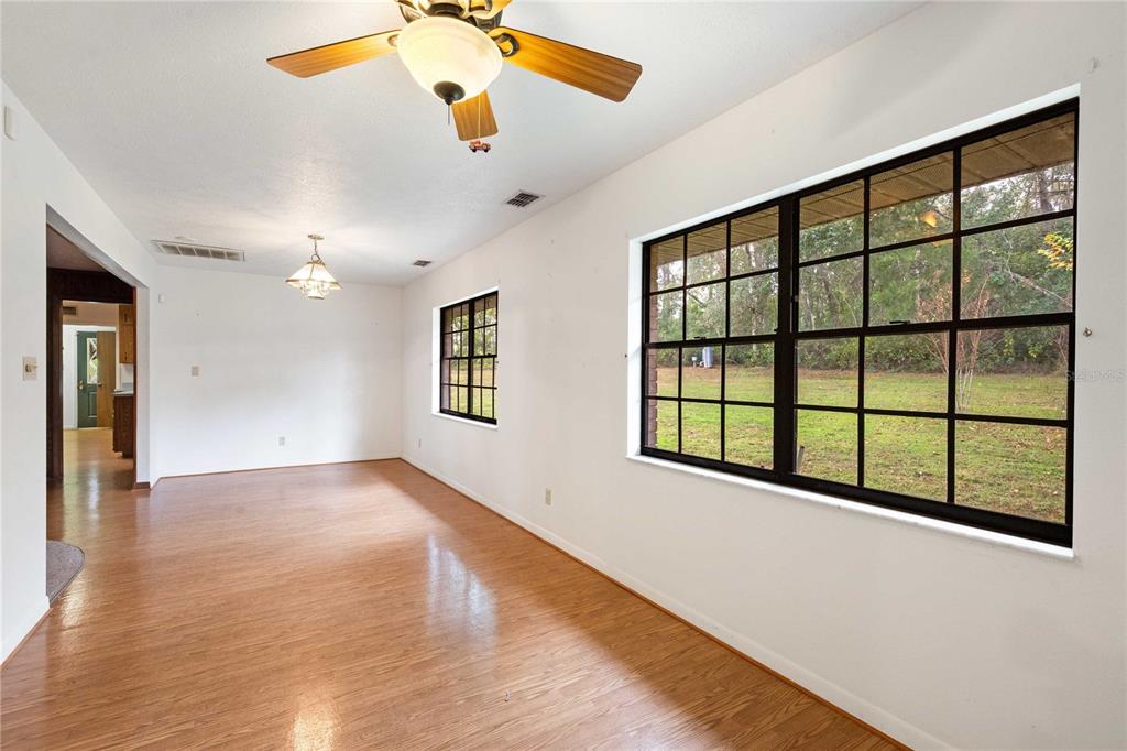 14835 Ramsey Road Dade City, FL 33523 - Photo 26 of 59 a view of an empty room with a window and wooden floor