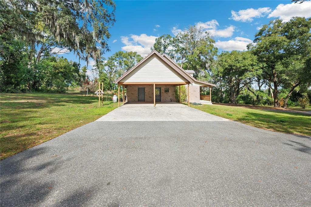 14835 Ramsey Road Dade City, FL 33523 - Photo 42 of 59 a big house with a big yard and large trees