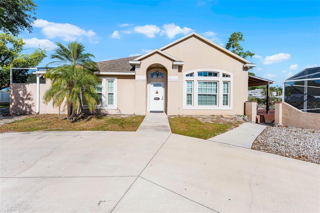 a front view of a house with a yard and potted plants