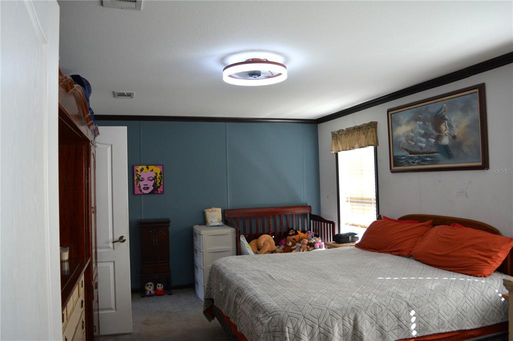 2640 Northeast 74th Street High Springs, FL 32643 - Photo 9 of 39 a bedroom with a bed and a chandelier