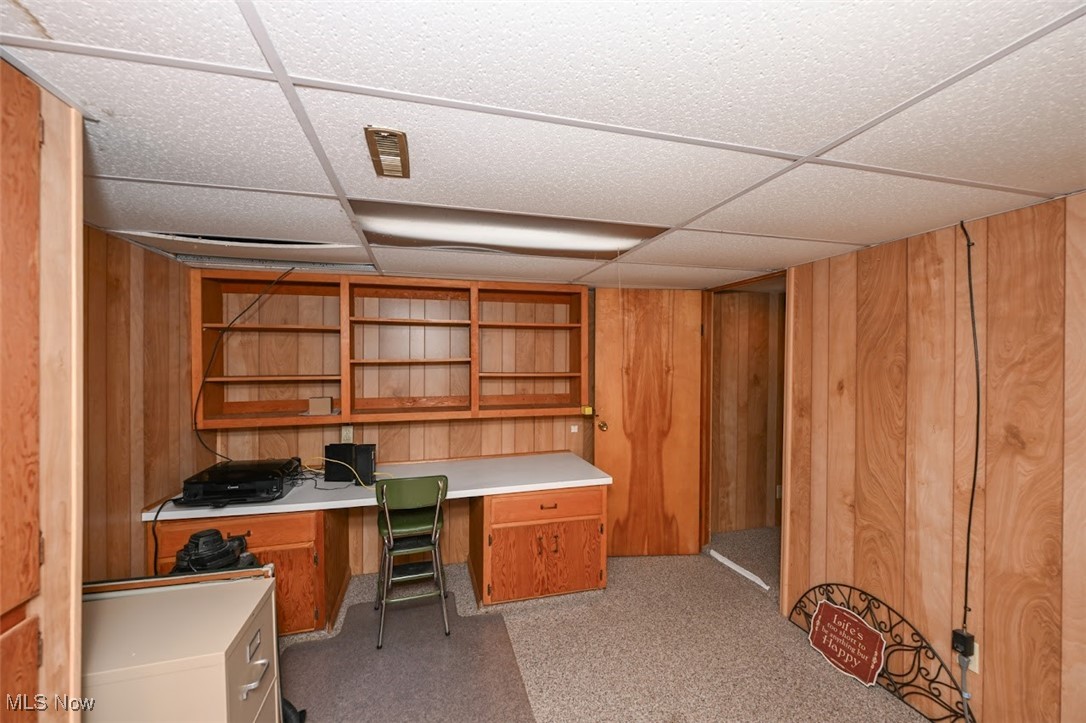 3305 Edington Road Akron, OH 44333 - Photo 30 of 46 Office with built in desk, wood walls, light colored carpet, and a drop ceiling in lower level