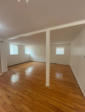 a view of empty room with wooden floor