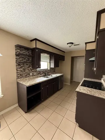 a kitchen with stainless steel appliances kitchen island granite countertop a stove and a sink