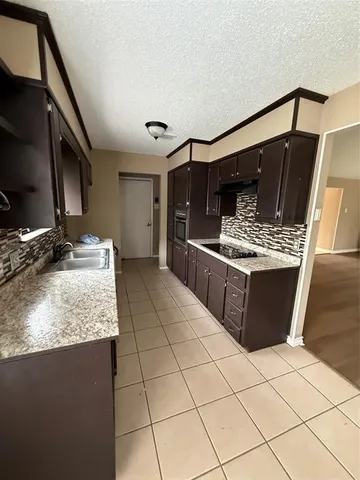a kitchen with stainless steel appliances granite countertop a sink stove and cabinets