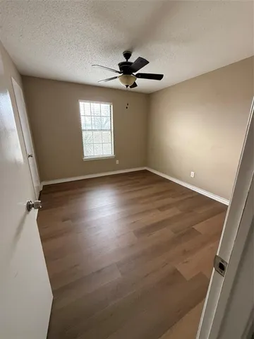 an empty room with windows and fan