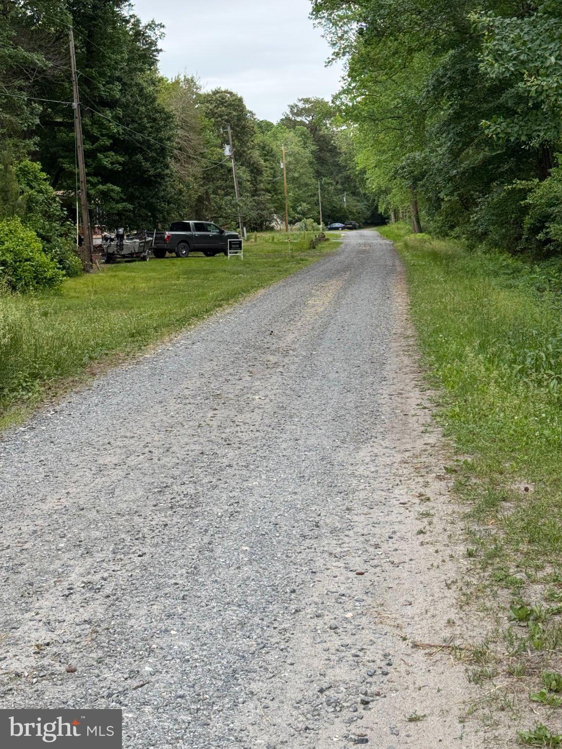 36129 New Marydels Road Frankford, DE 19945 - Photo 2 of 11 Serene gravel road through greenery.
