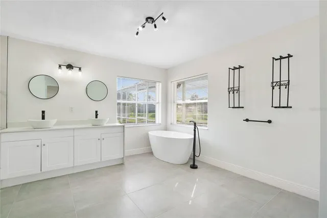 a spacious bathroom with a double vanity sink mirror and a bathtub