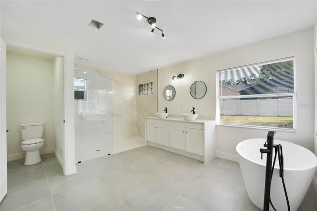 a spacious bathroom with a double vanity sink a mirror and a bathtub