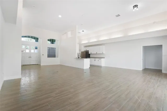 a view of empty room with wooden floor