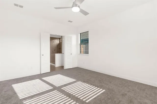 a view of a bedroom with wooden floor and a ceiling fan
