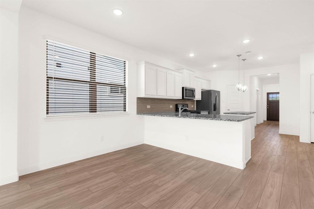 216 Town Pk Avenue Princeton, TX 75407 - Photo 8 of 19 a view of kitchen with stainless steel appliances granite countertop a stove top oven a sink dishwasher and a microwave oven on wooden floors