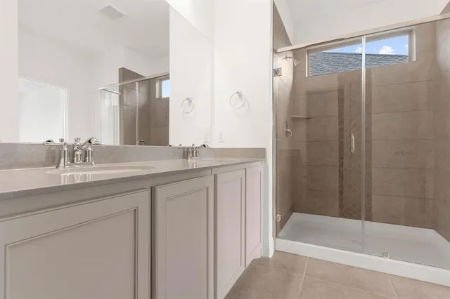 a bathroom with a granite countertop sink a mirror a bathtub and shower