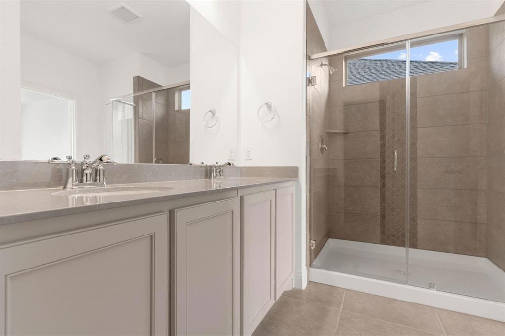 216 Town Pk Avenue Princeton, TX 75407 - Photo 9 of 19 a bathroom with a granite countertop sink a mirror a bathtub and shower