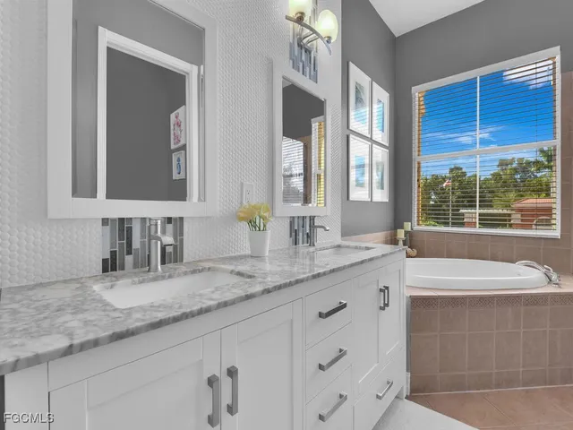 a bathroom with a granite countertop sink and a bathtub