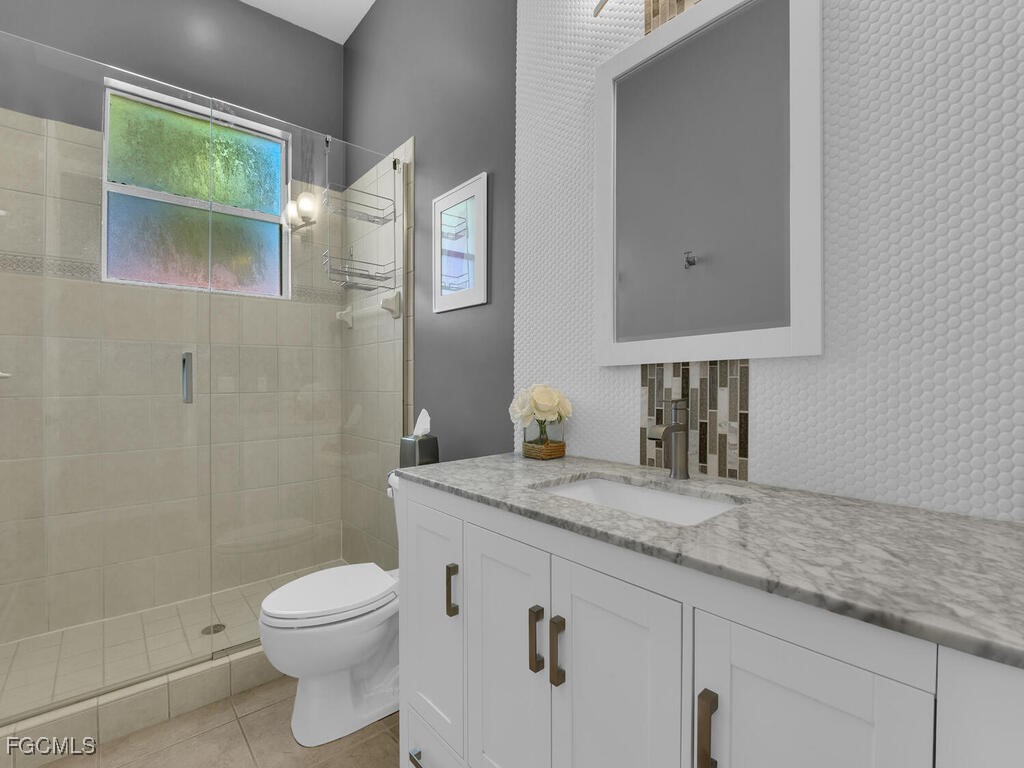 7241 Bergamo Way, Unit 201 Fort Myers, FL 33966 - Photo 17 of 26 a bathroom with a granite countertop sink a toilet and a mirror