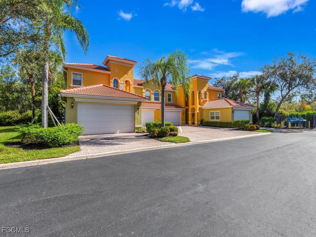 7241 Bergamo Way, Unit 201 Fort Myers, FL 33966 - Photo 20 of 26 a front view of a house with a yard and a garage
