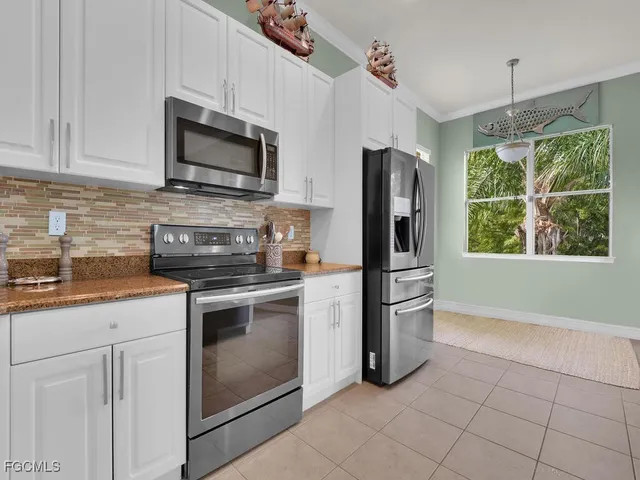 a kitchen with stainless steel appliances granite countertop a stove a refrigerator and a microwave