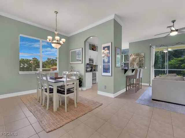 a dining room with furniture a chandelier and window