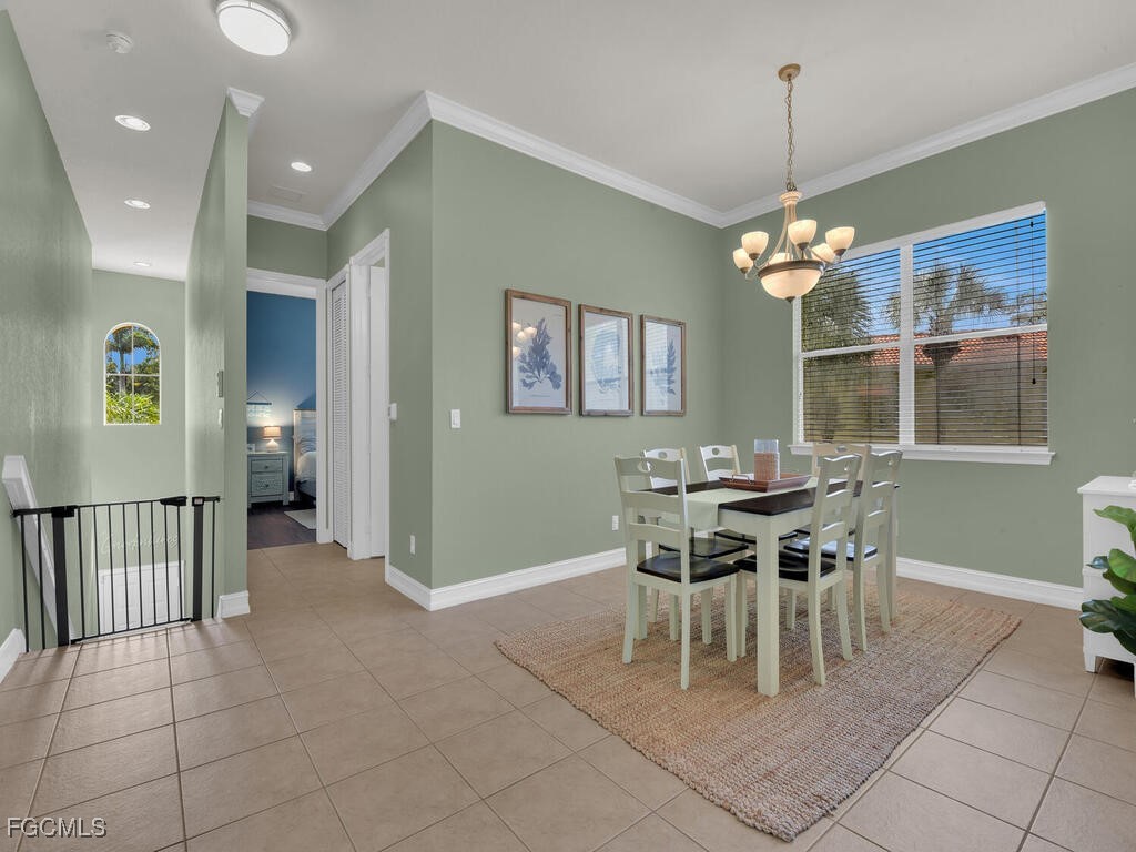 7241 Bergamo Way, Unit 201 Fort Myers, FL 33966 - Photo 9 of 26 a view of a dining room with furniture and chandelier
