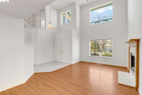 a view of an empty room with a window and fireplace