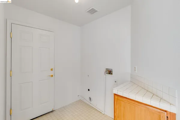 a view of a kitchen and an entryway with wooden floor